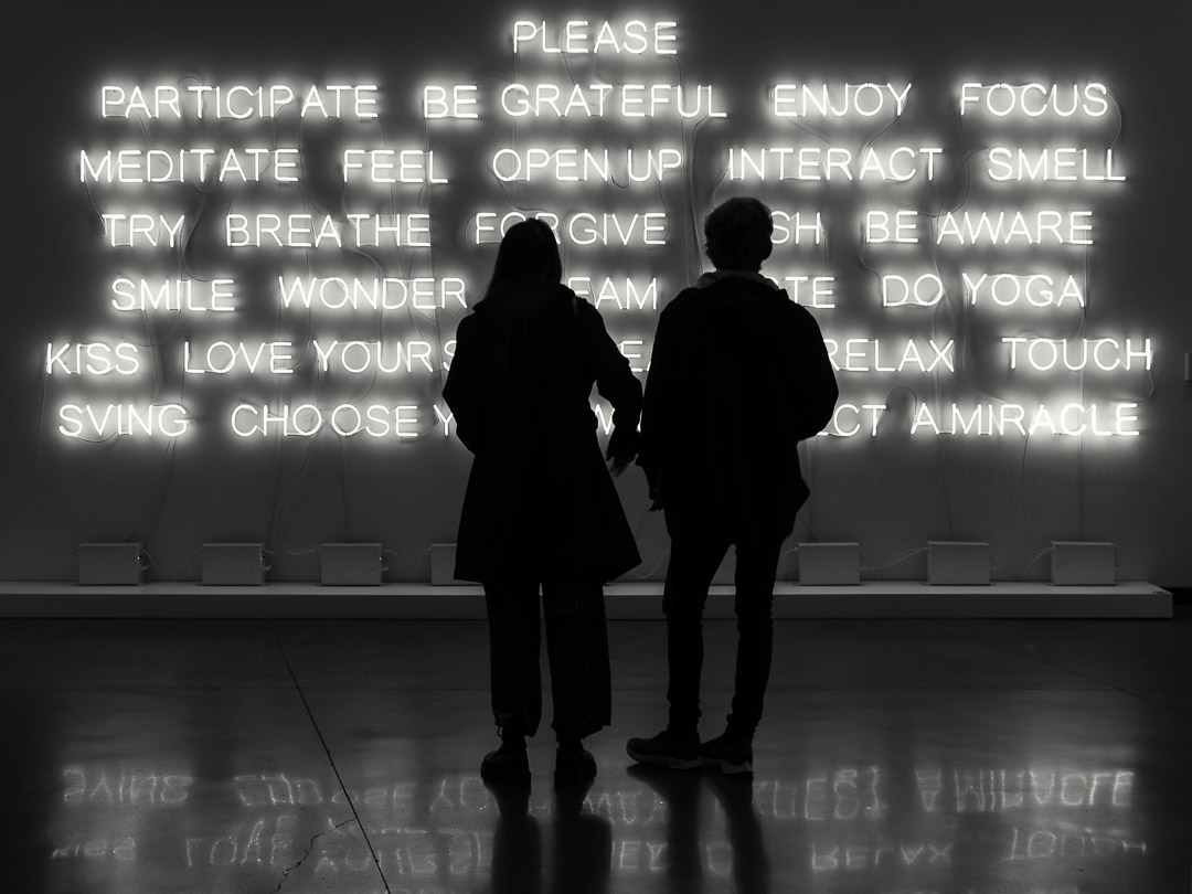 Photograph of a couple standing in front of an art installation providing life advice