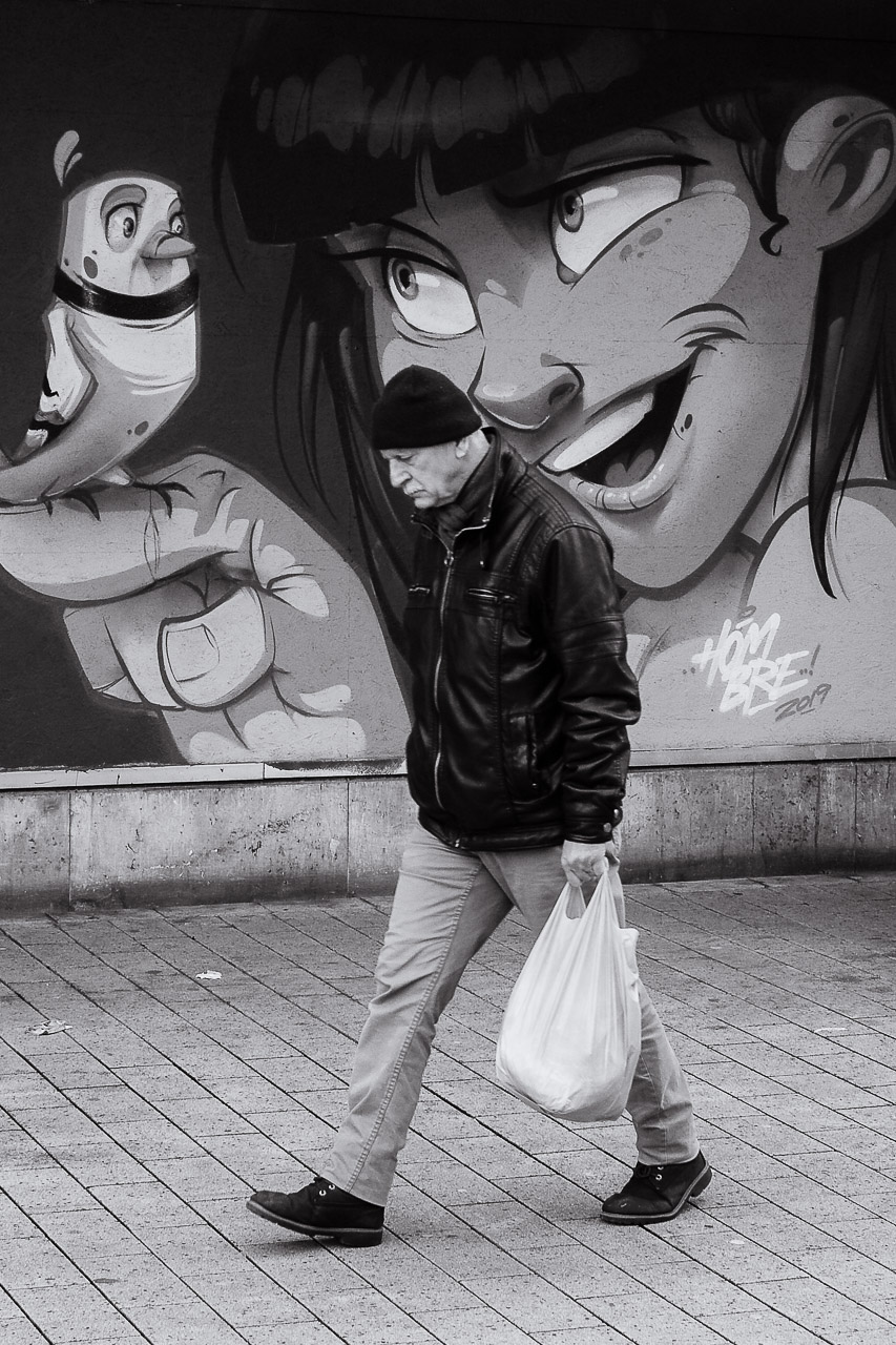 Man walking past a comic mural - Street Photography Nürnberg