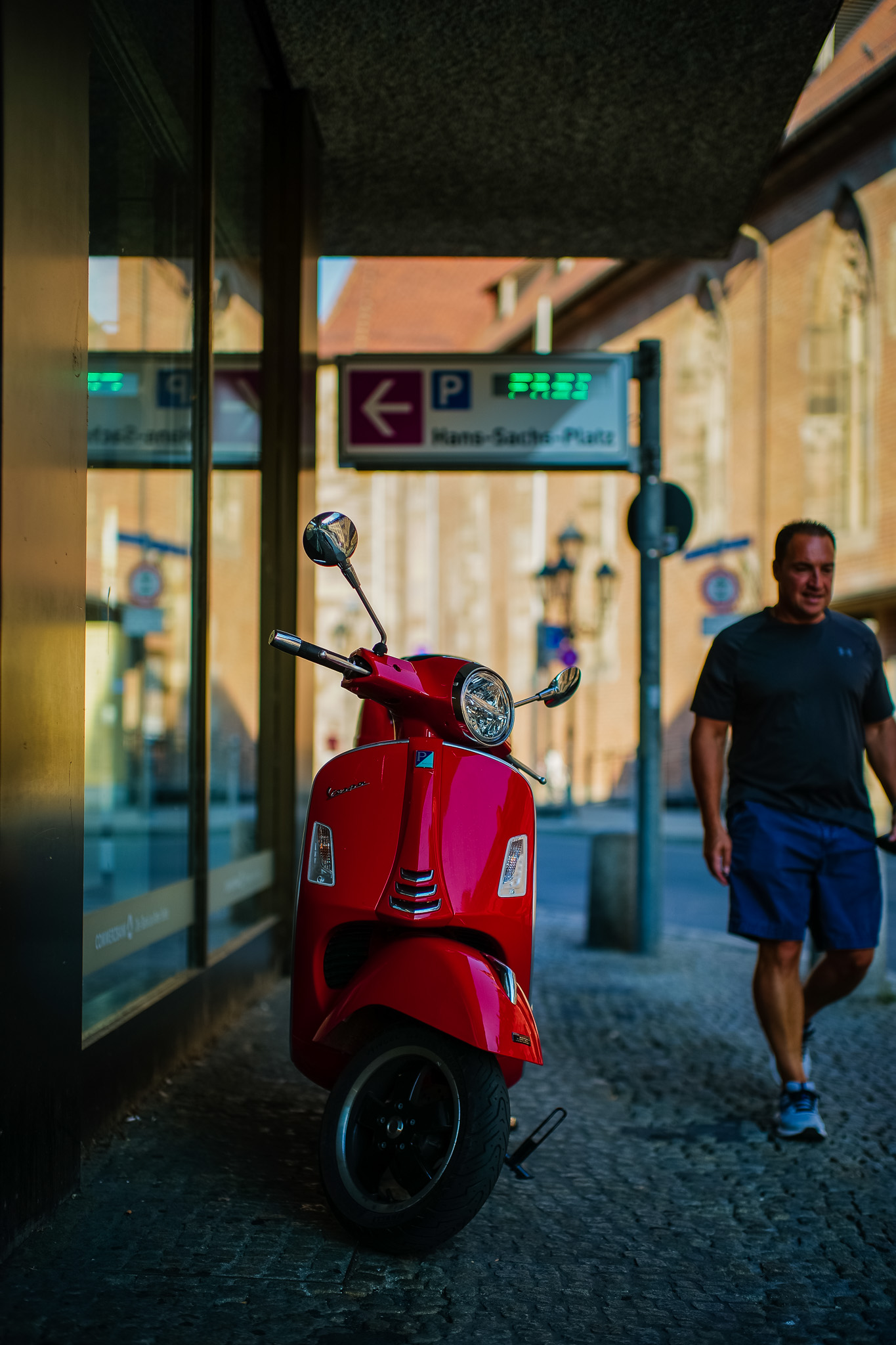Man passing a red Vespa