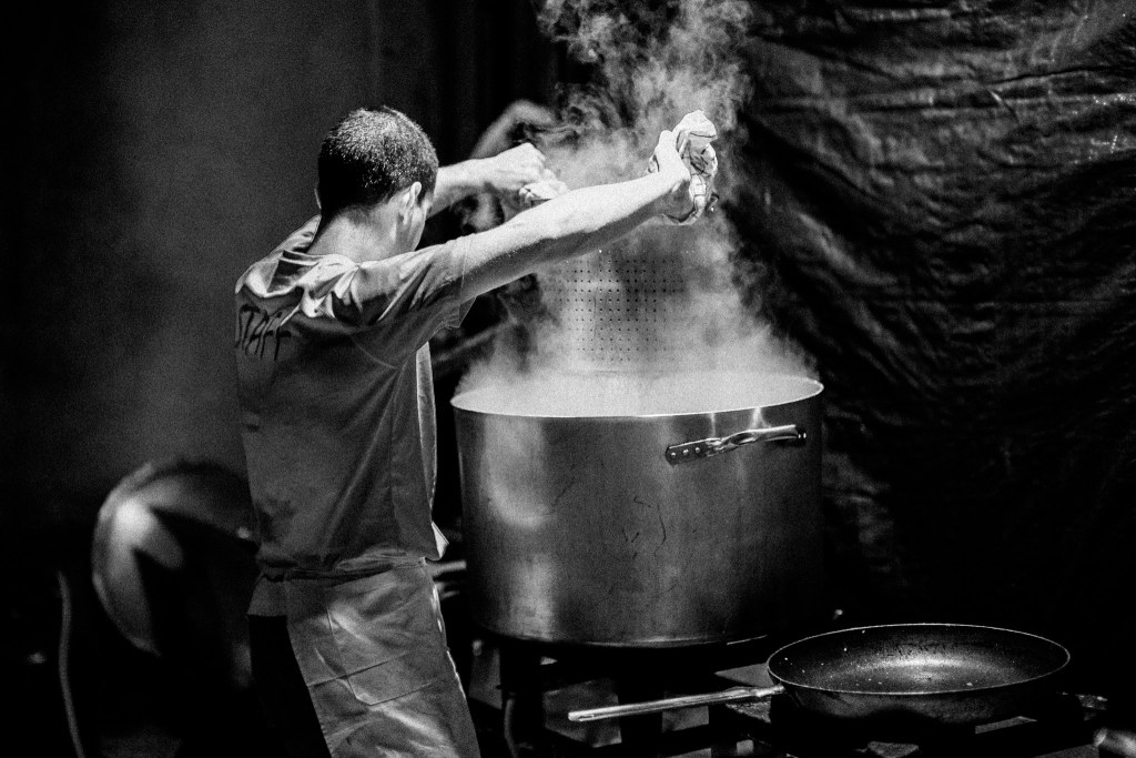 Cook in front of a steaming pot of pasta
