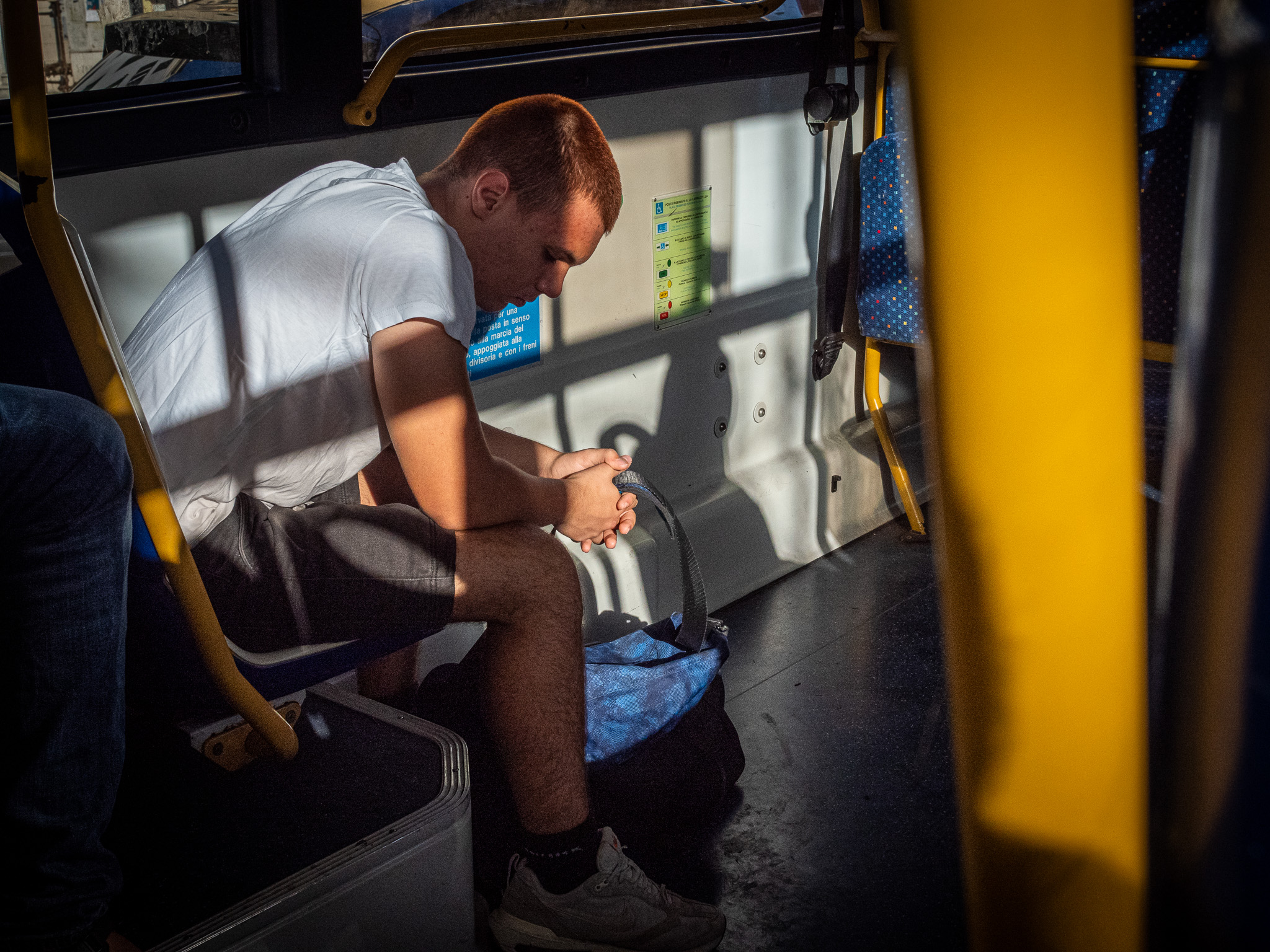 Colorful street photo of a passenger sitting in a bus