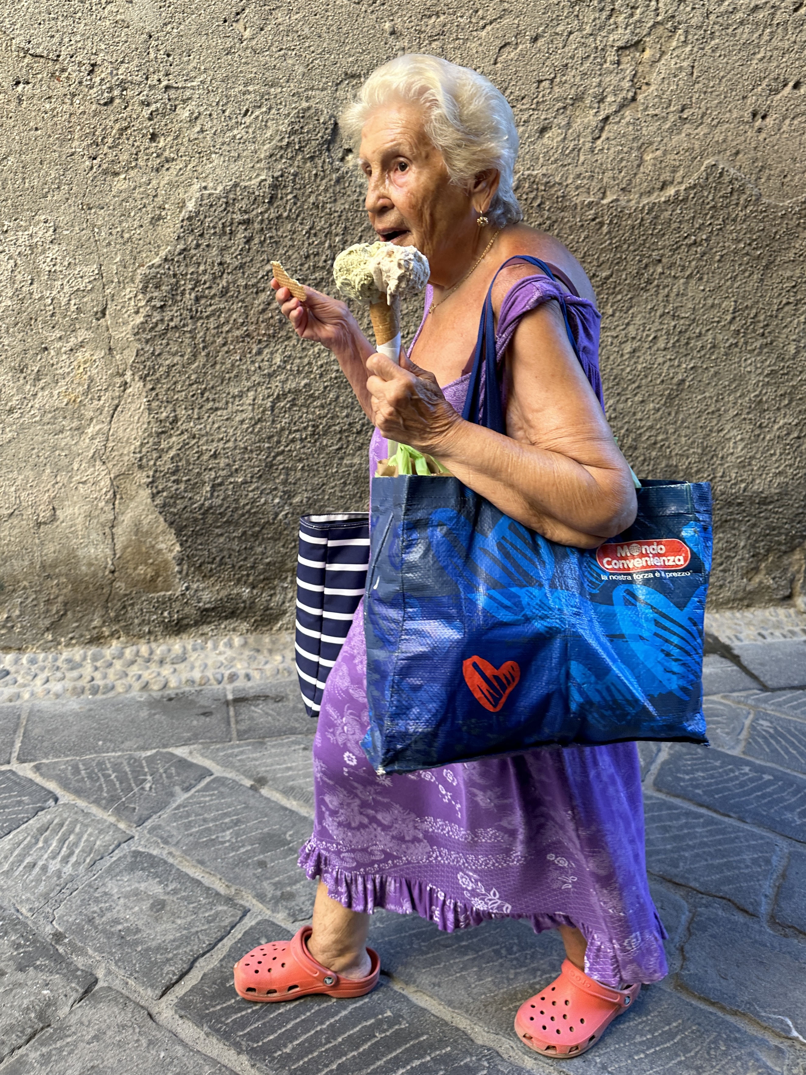 Old Lady in a colorful beach dress enjoying an ice cream