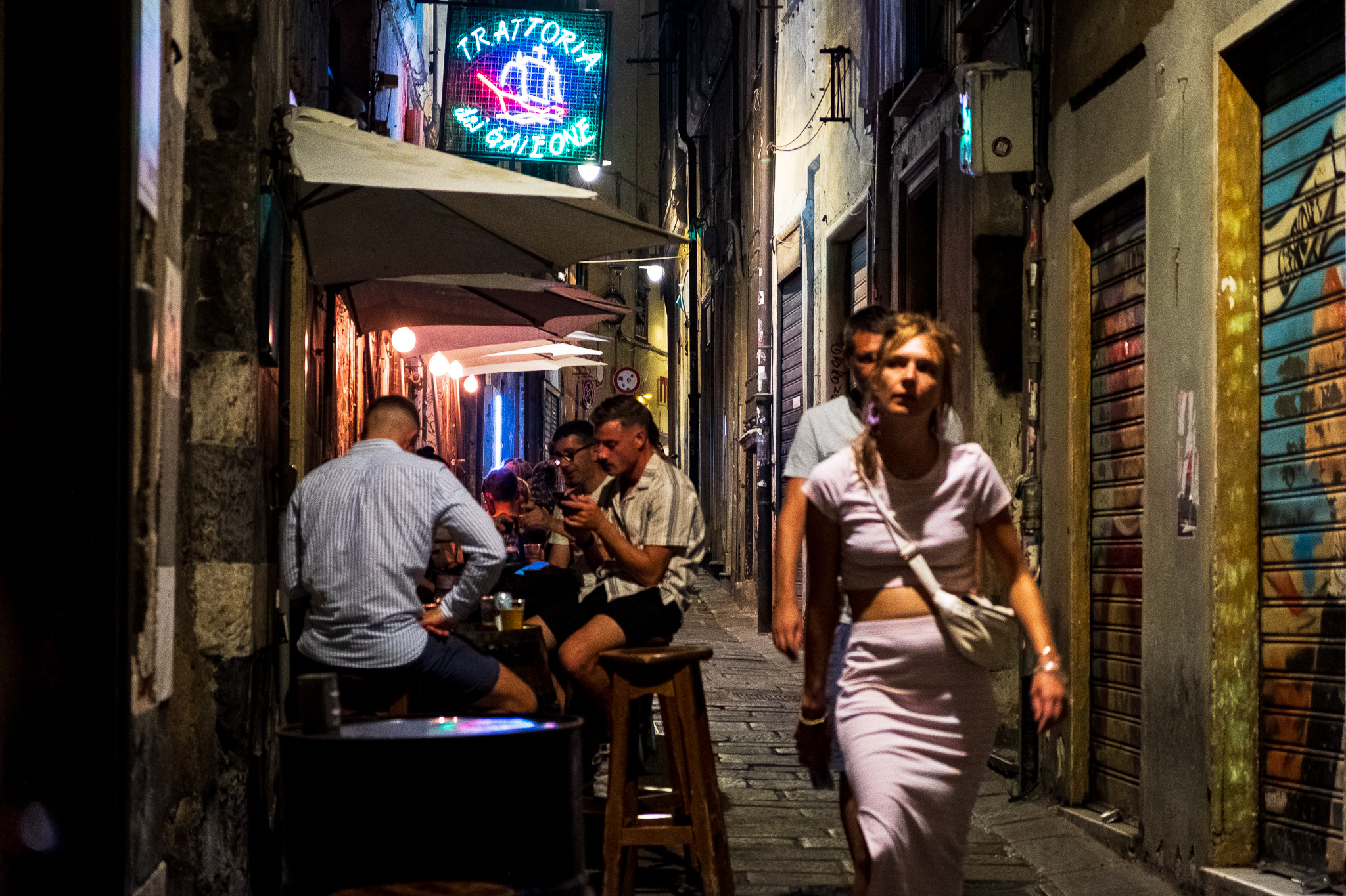 Lady with a dress walking through Genoa's Centro Storico at night