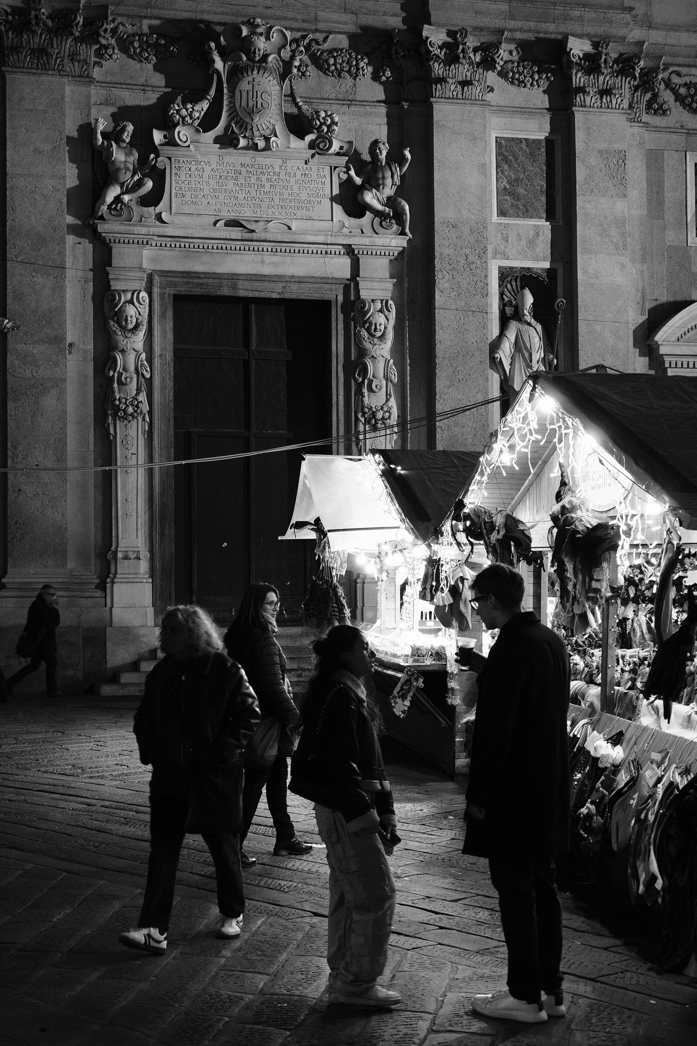 People standing at Christmas stalls on Piazza Matteotti in Genoa's Centro Storico