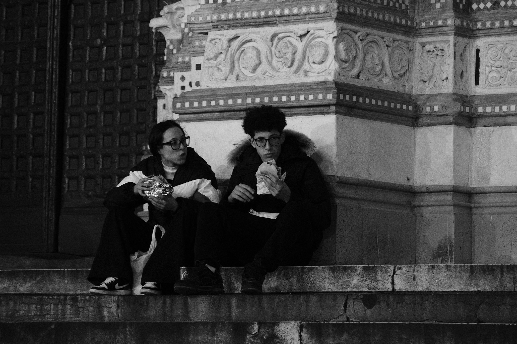 People eating on the stairs of San Lorenzo in Genoa's Centro Storico