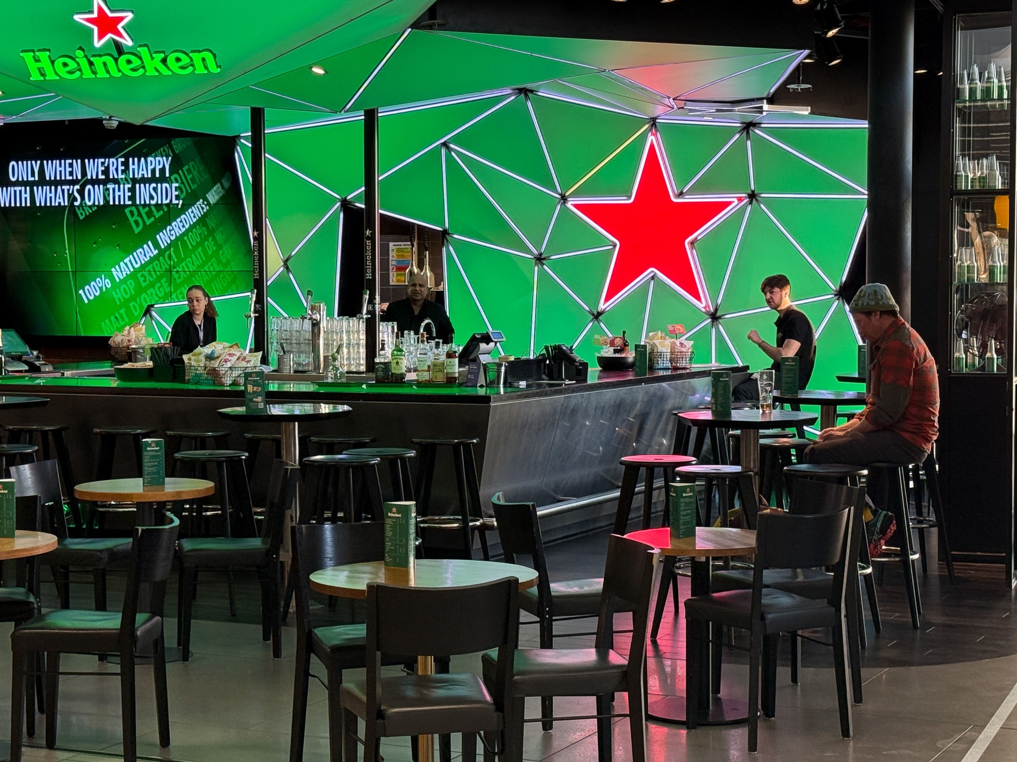 Customers sitting in a Heineken Bar at Amsterdam Airport on a travel day