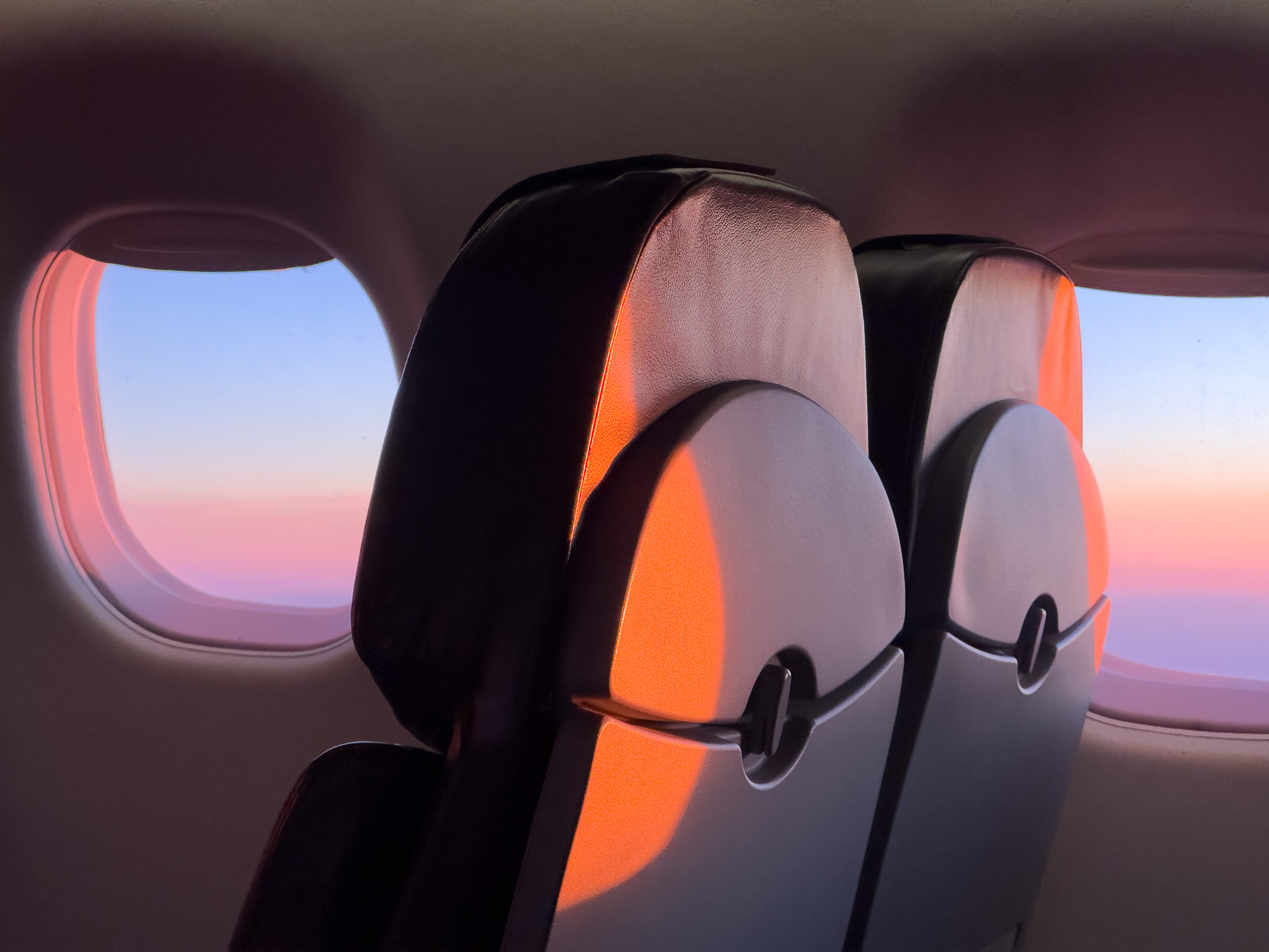 Sunrise reflecting on the back of airplane seats