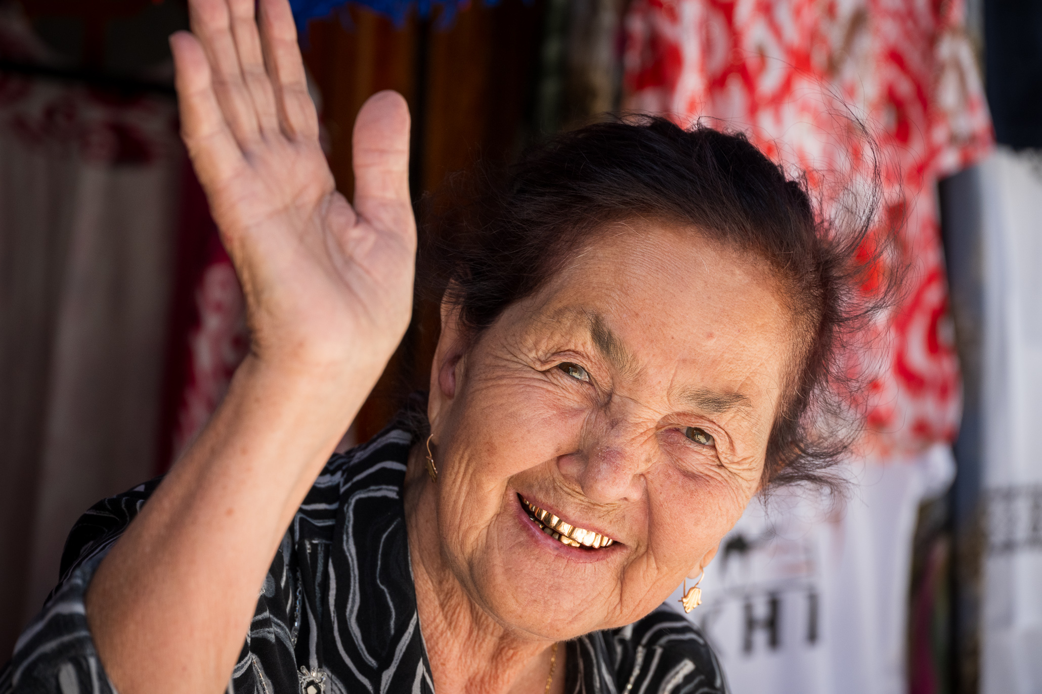 Uzbek Lady with golden teeth waving at the photographer
