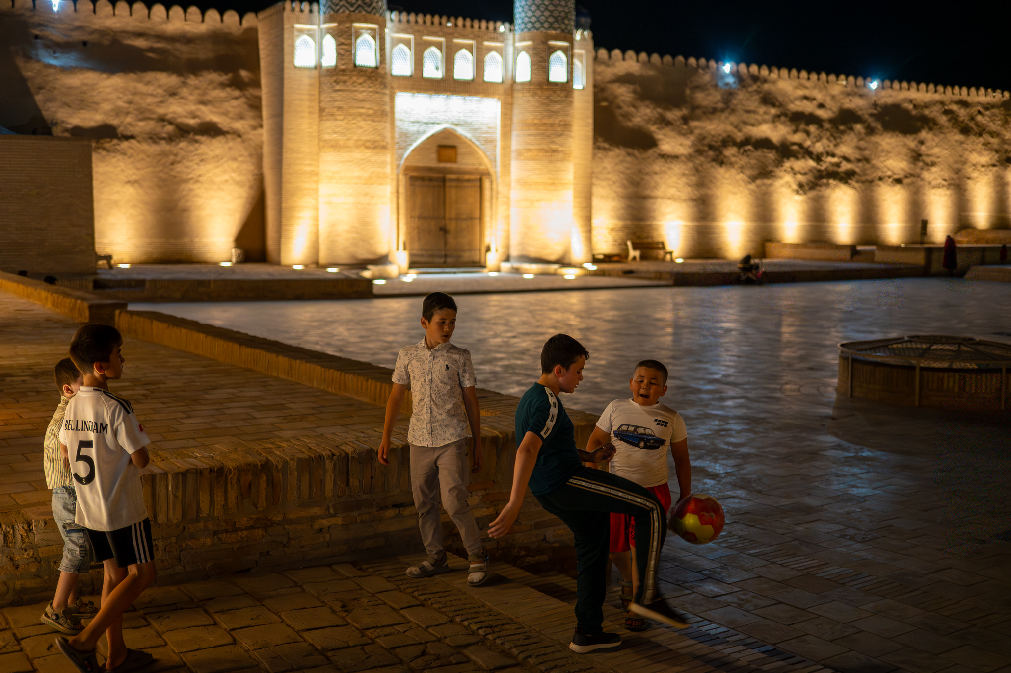 Boys playing soccer at night in Khiva