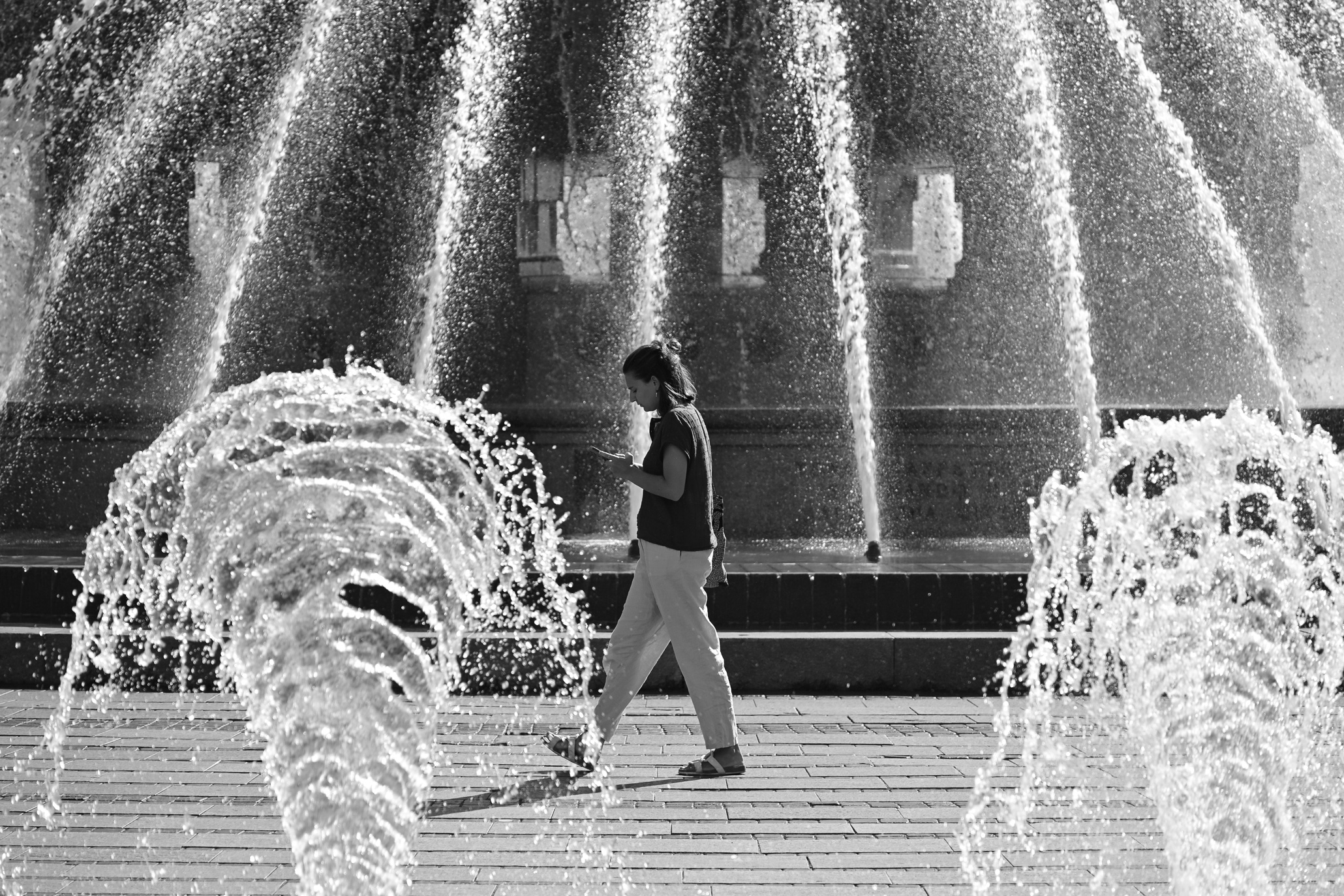 A lady in front of a fountain, enjoying the summer in the city
