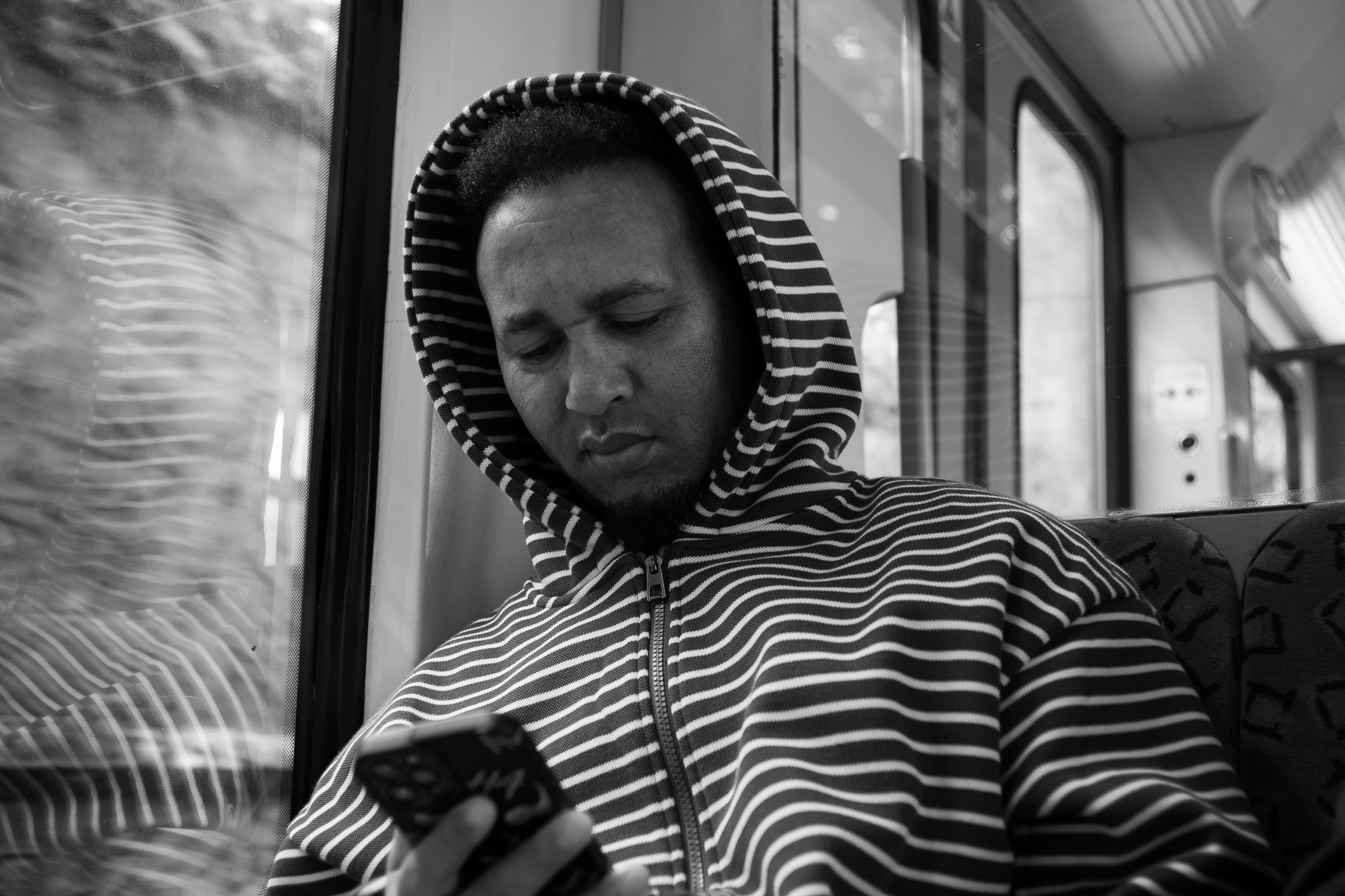 Guy in a striped shirt riding the Berlin subway into town