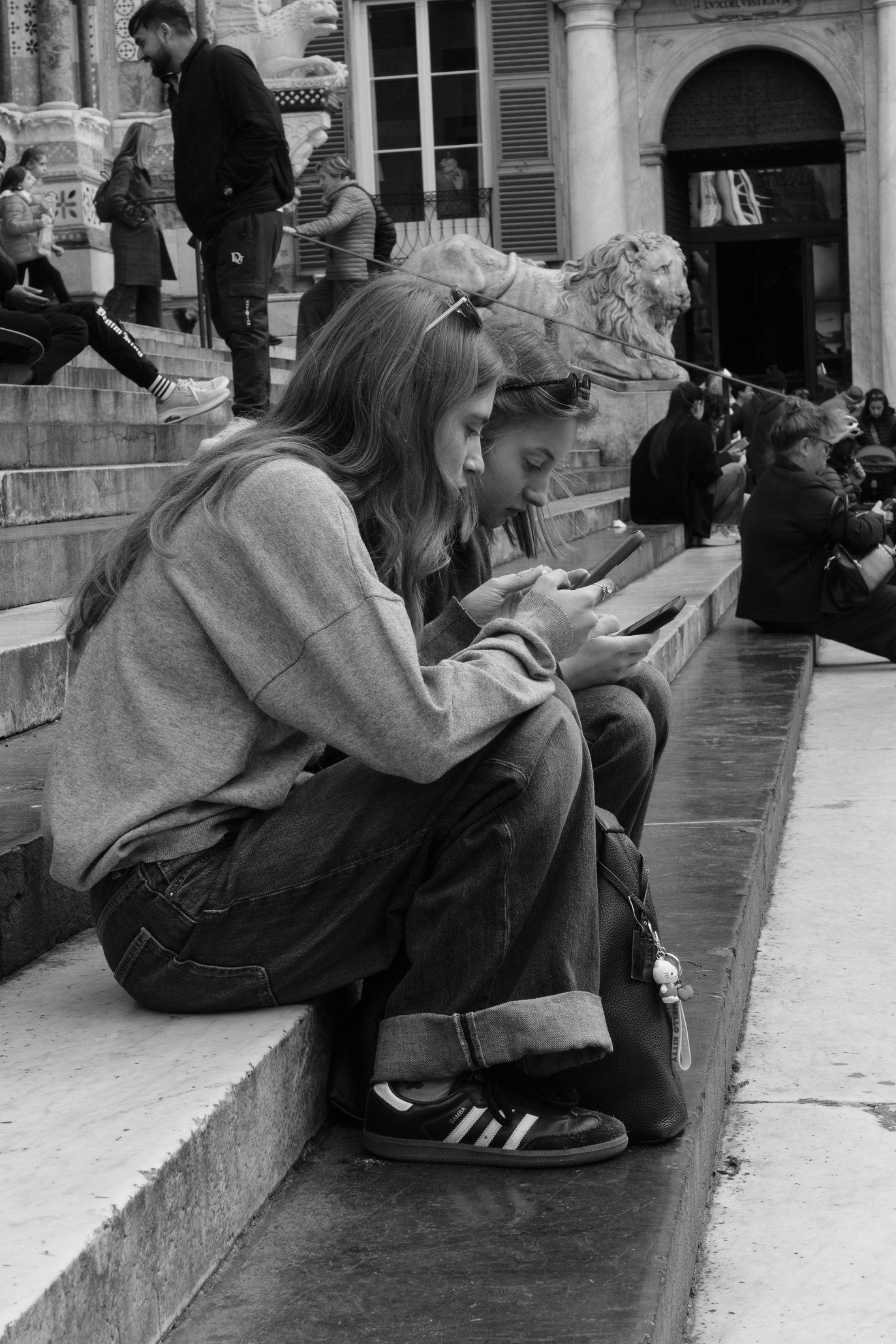 Two girls sitting on the steps of San Lorenzo Cathedral in Genoa