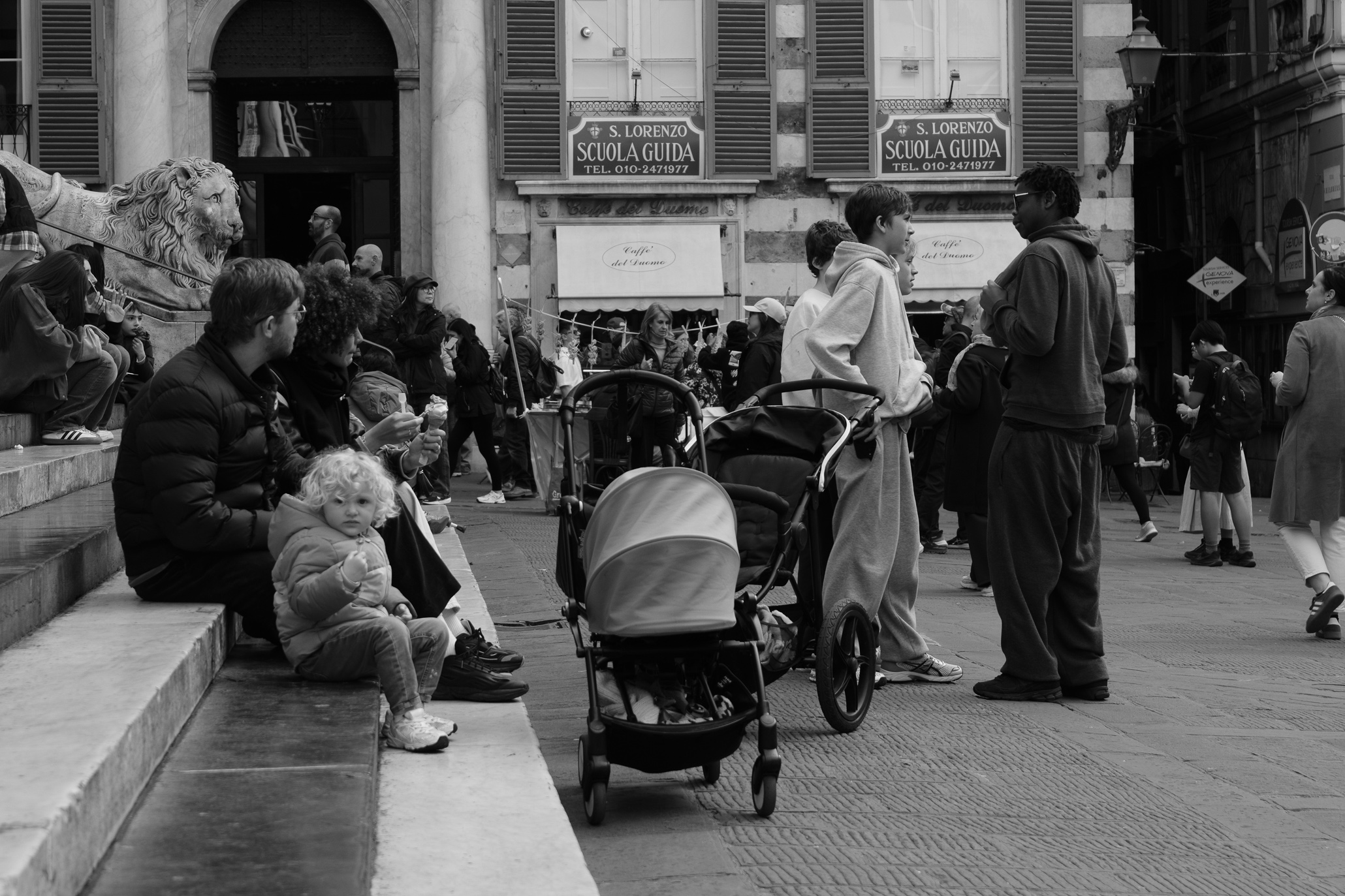 People sitting on the steps of San Lorenzo Cathedral in Genoa