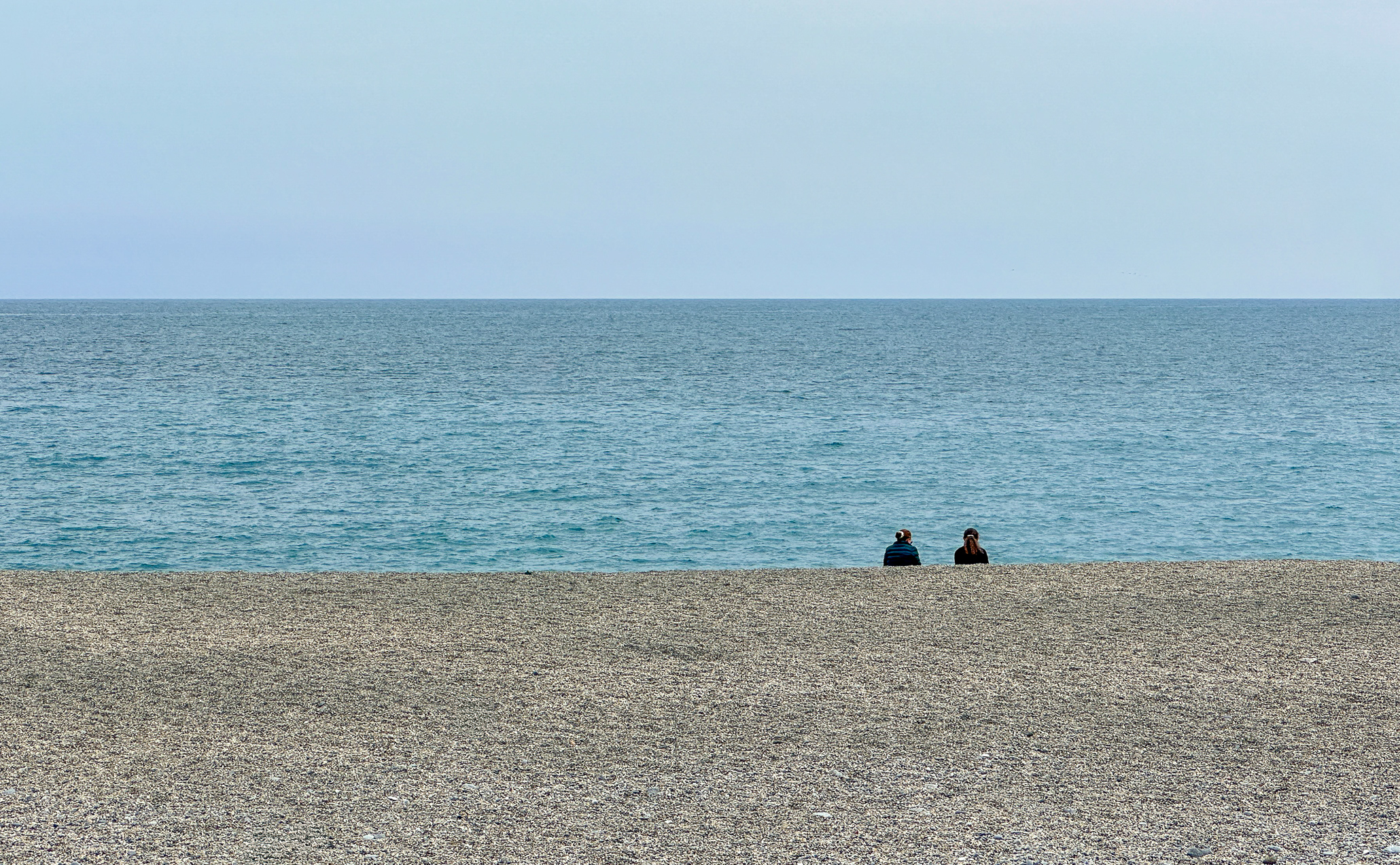 Two people by the sea watching the horizons