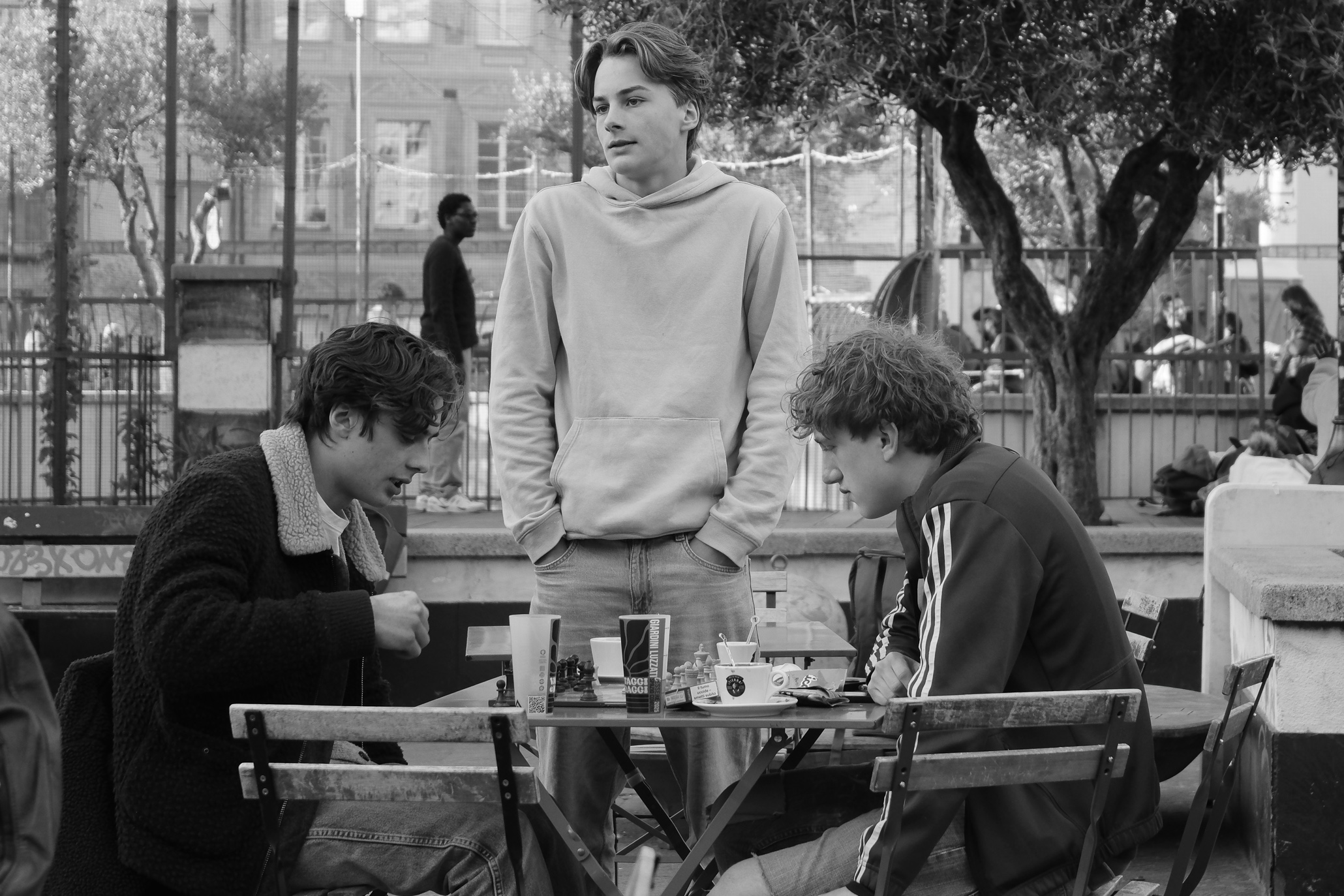 Three teenagers playing chess in Giardini Luzzati Genoa