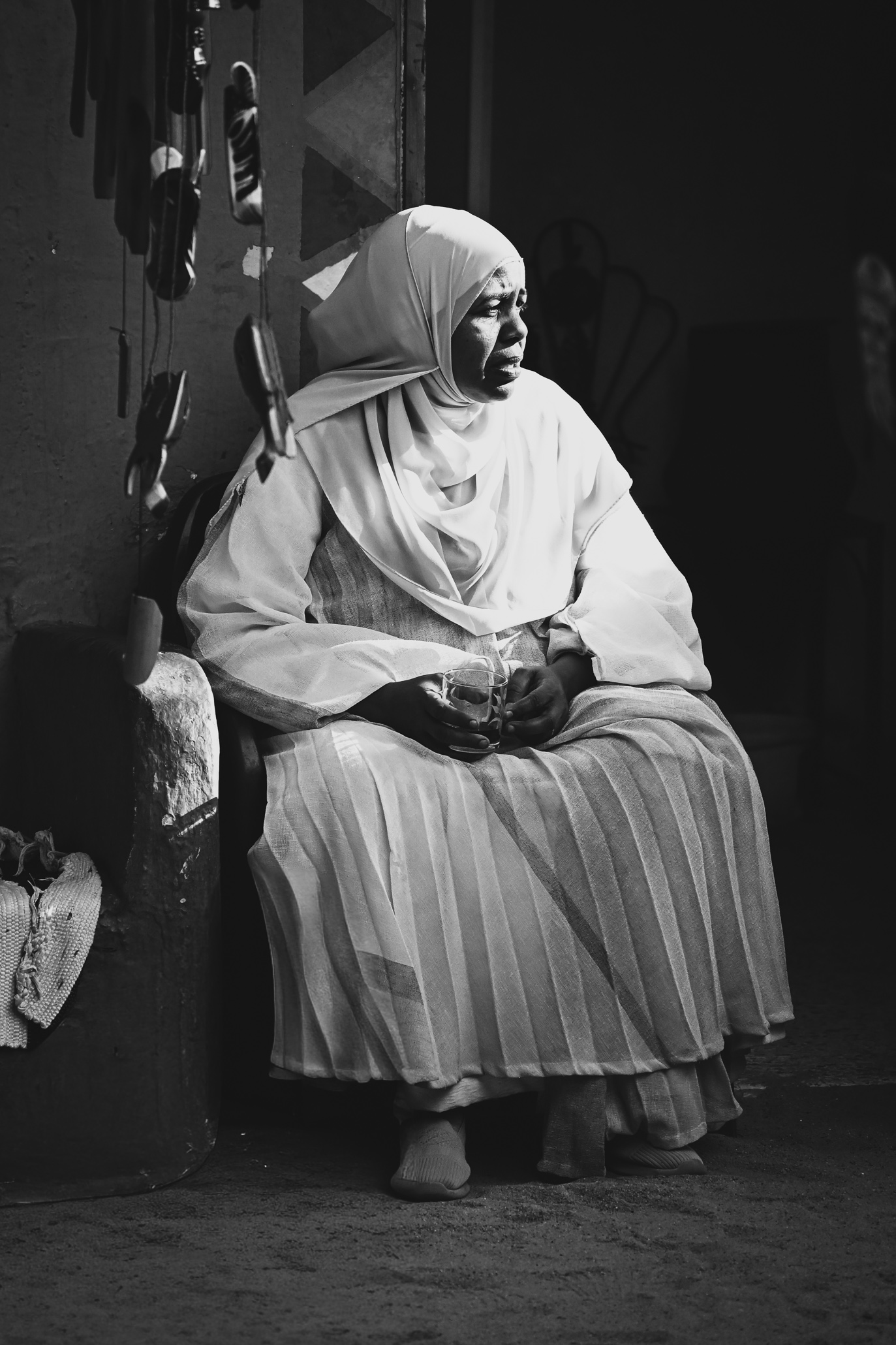A Nubian woman clad in a traditional dress sitting in the door of her house in a Nubian village on the banks of the Nile in Upper Egypt