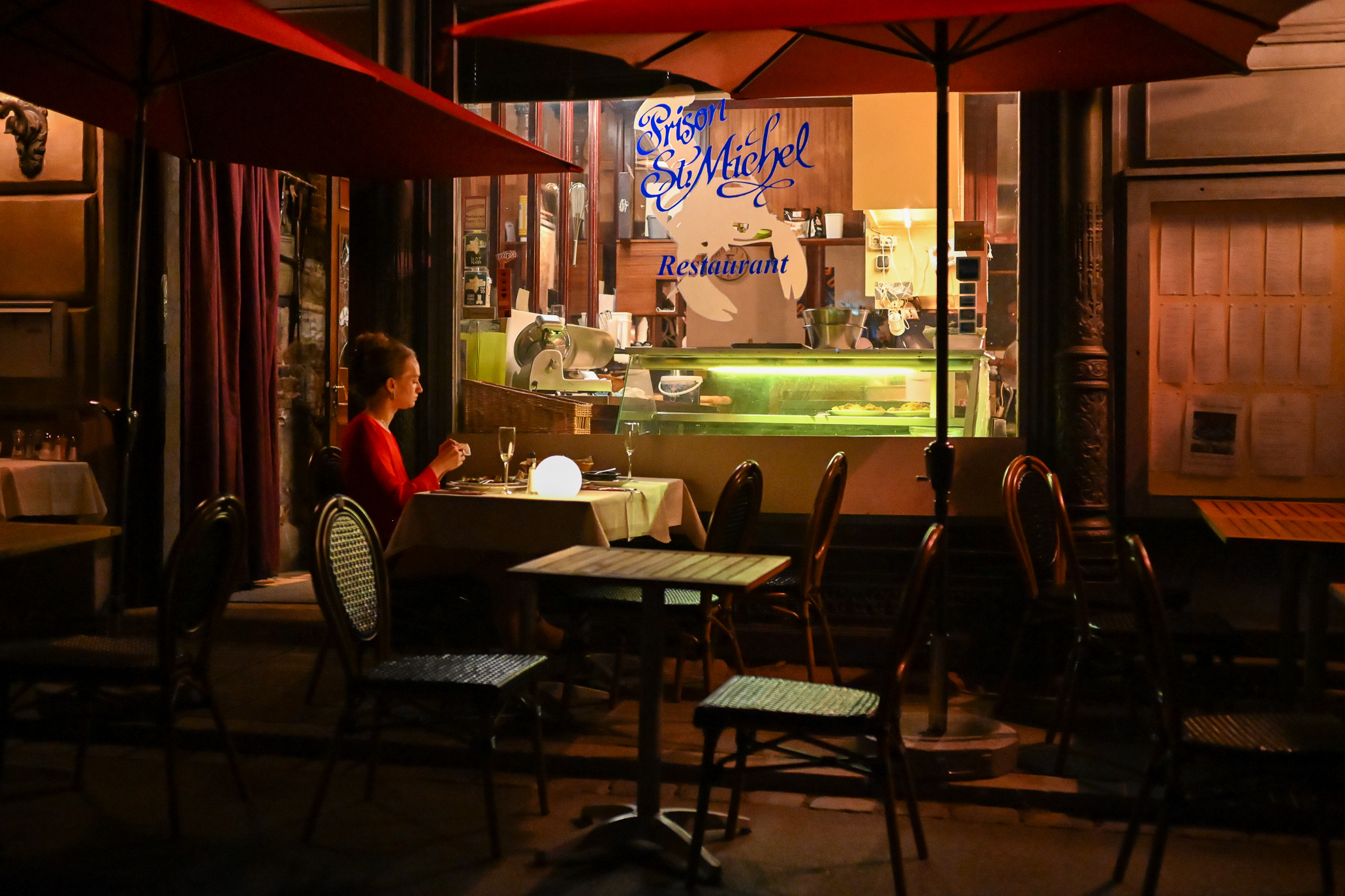 The solitaire guest is a lady in a red dress sitting in front of a restaurant in Nuremberg, Germany